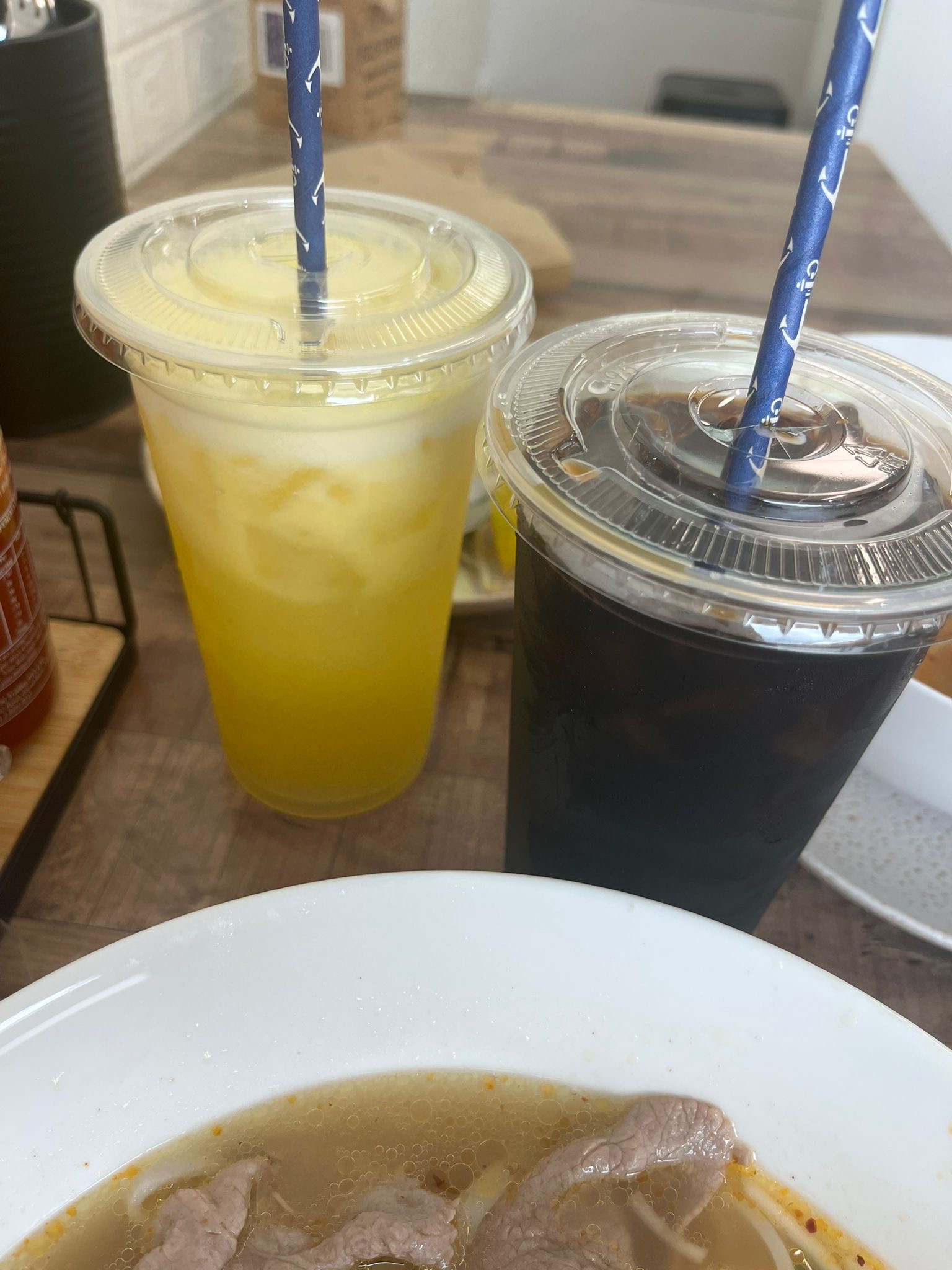 An iced orange juice and a Vietnamese iced coffee on a table