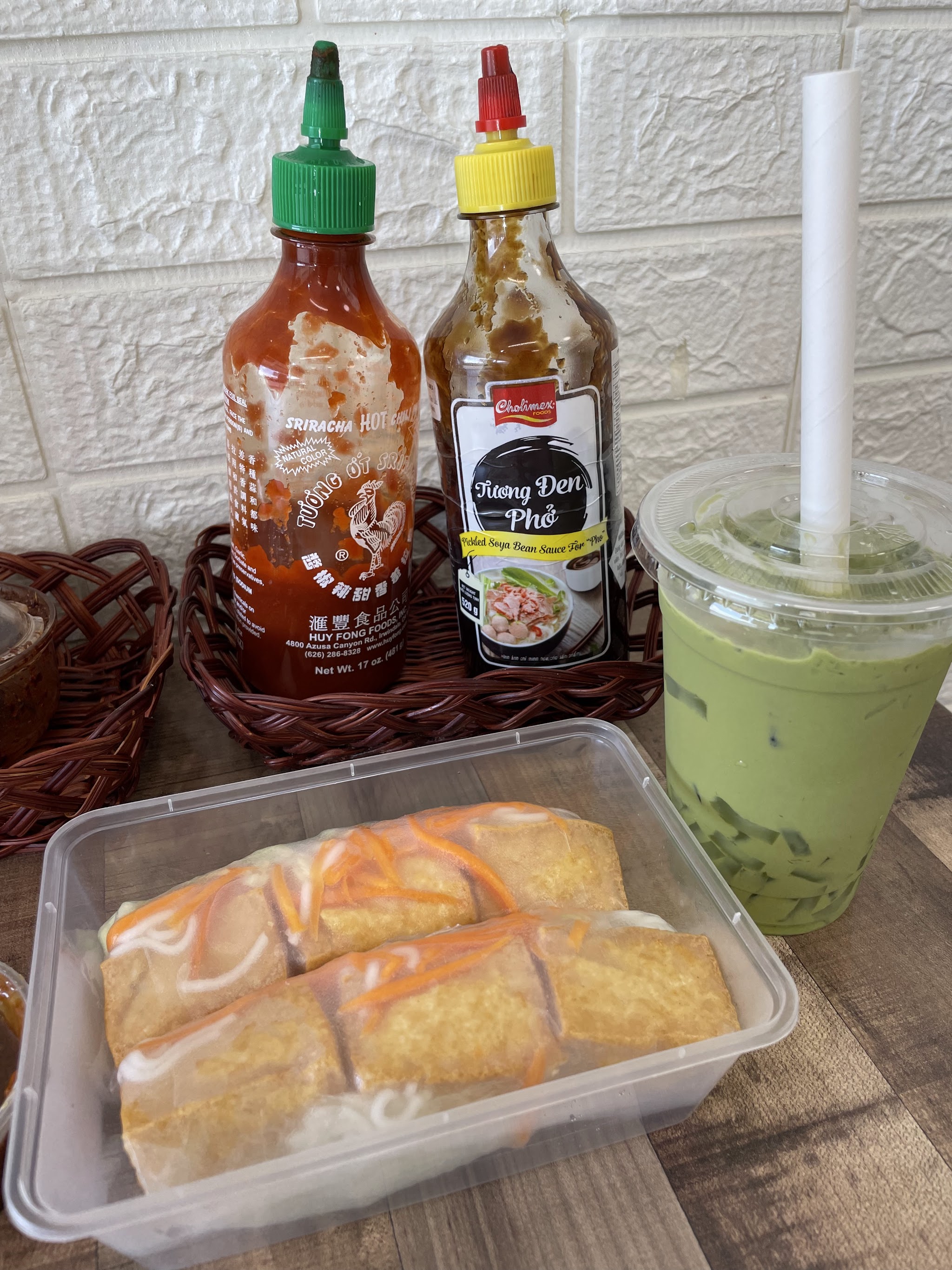 Fried rice paper rolls with dipping sauces and an iced drink
